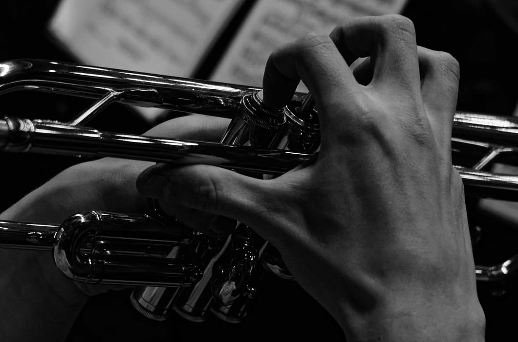 a hand playing a trumpet