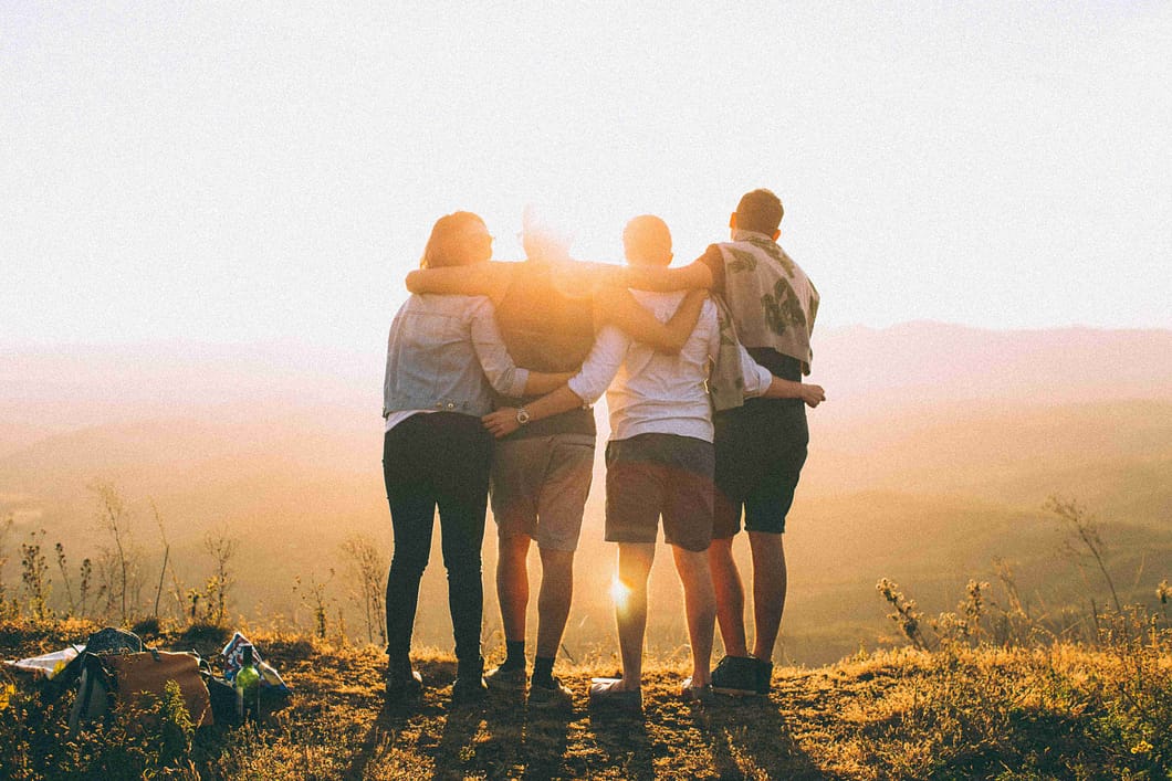 a group of people hugging on a hill